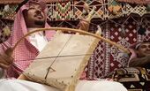 عازف ربابة في بيت الشَعر، وتظهر تطريزات السدو خلفه.