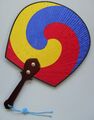 Hand fan with a tricolored taegeuk design