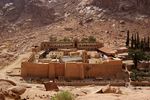 A monastery with high walls in a mountain desert area