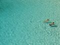 Cyan is the color of shallow water over a sandy beach. The water absorbs the color red from the sunlight, leaving a greenish-blue color.
