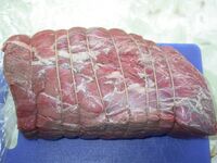 A 3 كيلوغرام (6.6 lb) top round roast of beef, tied and ready to be browned and roasted