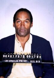 Simpson dressed in a suit, with a number identifier in front of him