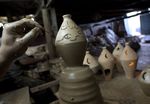 صانع فخار فلسطيني بكتب "رمضان كريم" على فانوس من الطين في ورشته بمدينة غزة، 17 أغسطس 2009.