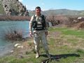 A Kurdish Army Peshmerga "Special Forces" Soldier places his AKM assault rifle on the ground to pose for a photograph at a river stream located in the countryside near Dahuk.
